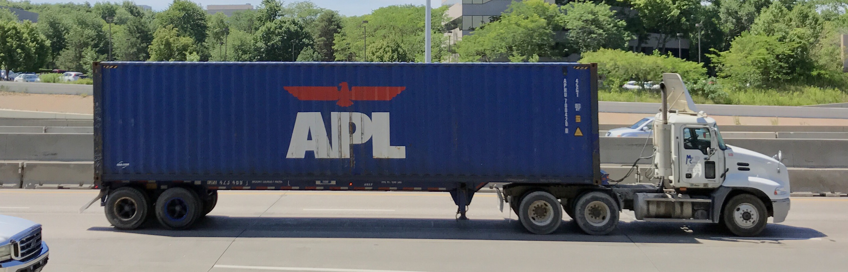 Camion transportant un conteneur APL sur route